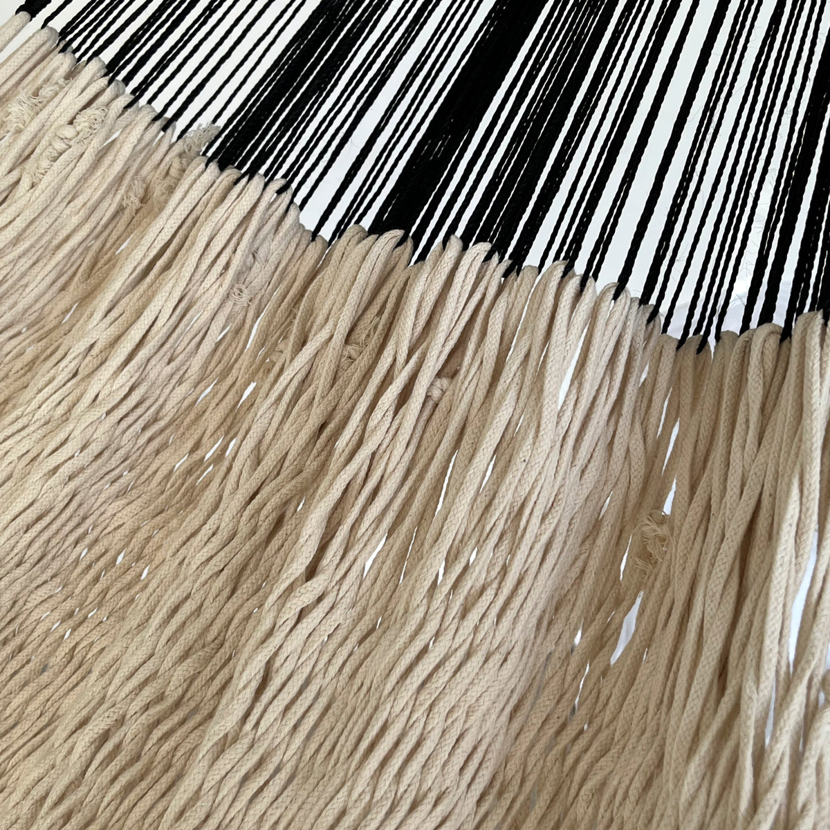 Detalle de la unión entre el cuerpo y el brazo de una hamaca yucateca artesanal de algodón hilo cuenda beige