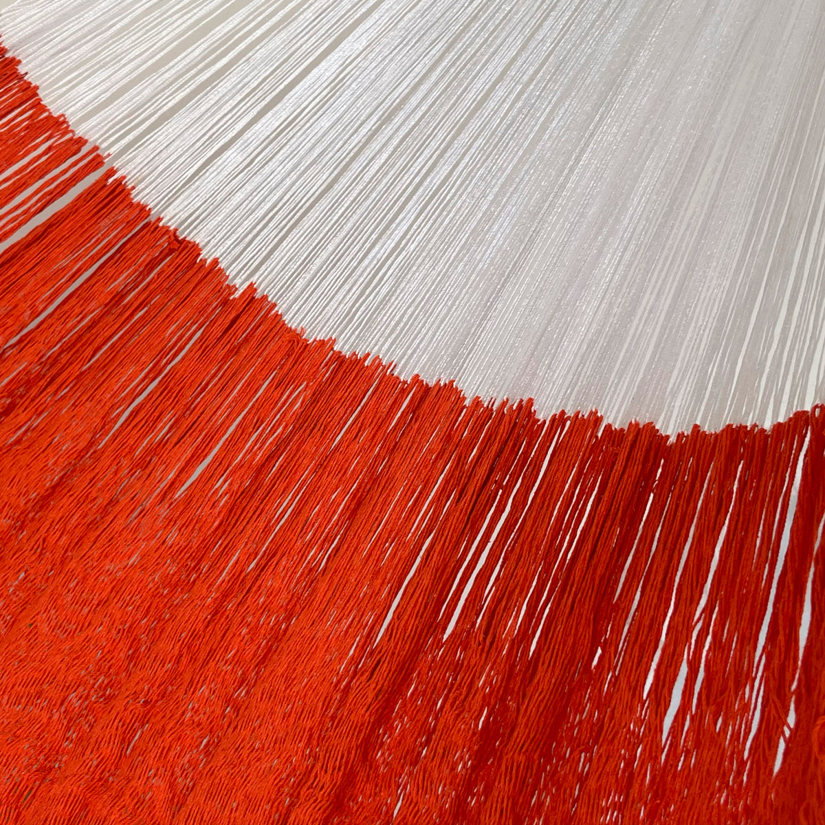 Detalle de la unión entre el cuerpo y el brazo de una hamaca yucateca artesanal de algodón king size naranja
