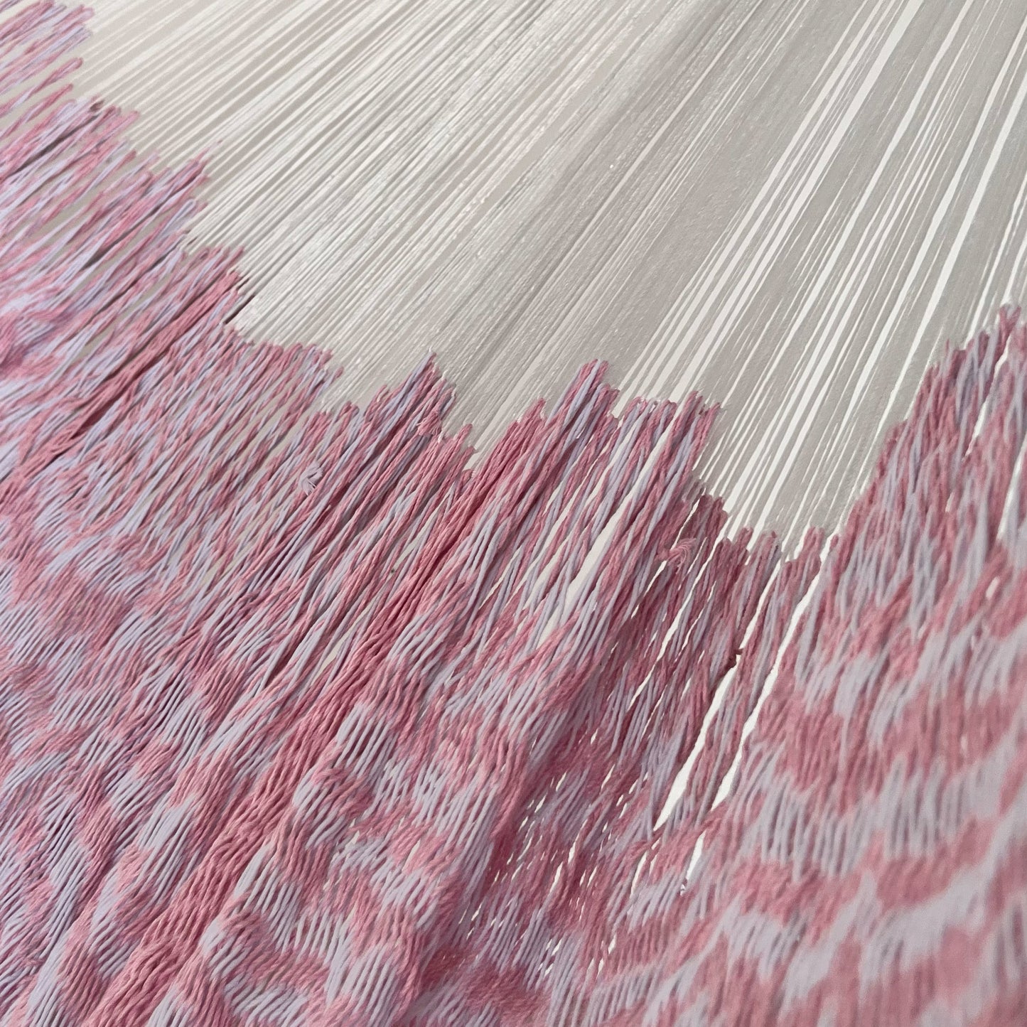 Unión entre cuerpo y brazo de hamaca Yucateca artesanal de algodón suave color blanco y rosa claro