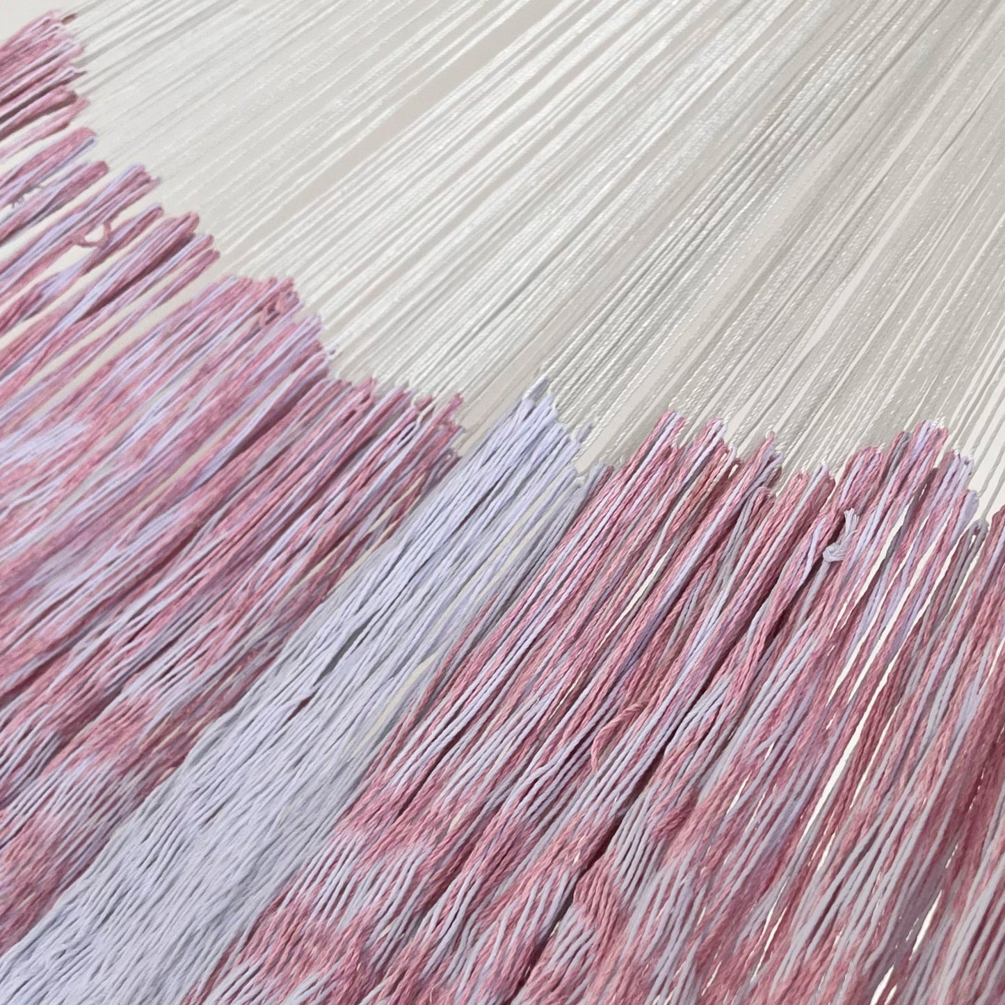 Unión entre cuerpo y brazo de hamaca Yucateca artesanal de algodón suave color blanco y rosa claro