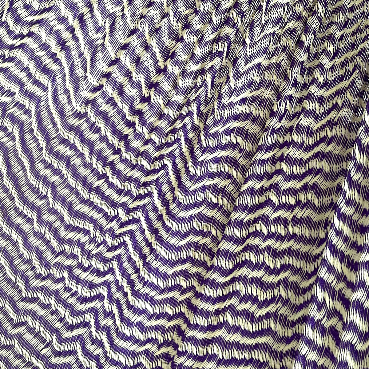 Primer plano del tejido de nylon suave de una hamaca yucateca artesanal color morado y beige