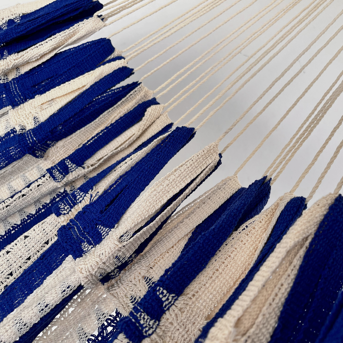 Detalle de la unión entre el cuerpo y el brazo de hamaca mexicana azul y beige de algodón