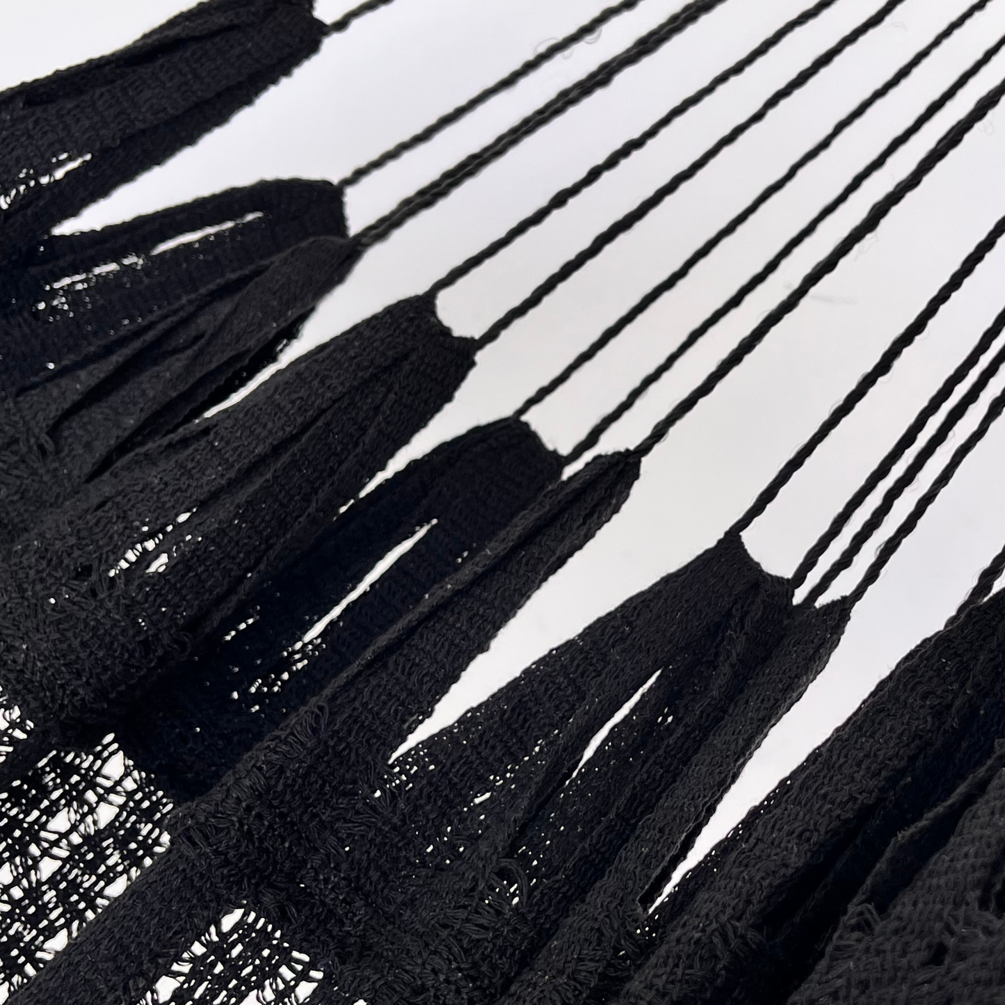 Detalle de la unión entre el cuerpo y el brazo de hamaca negra de algodón