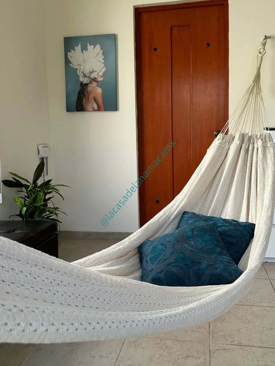 Hamaca mexicana de algodón beige colgada en dormitorio interior