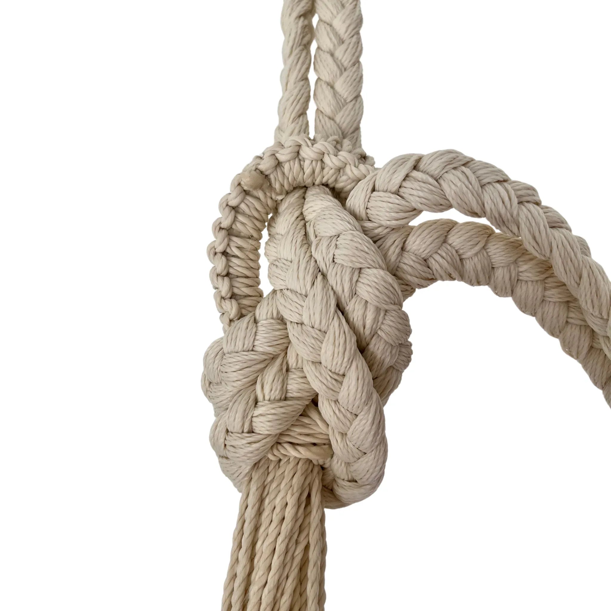 Nudo de cuerda de nylon beige artesanal unido al brazo de una hamaca 