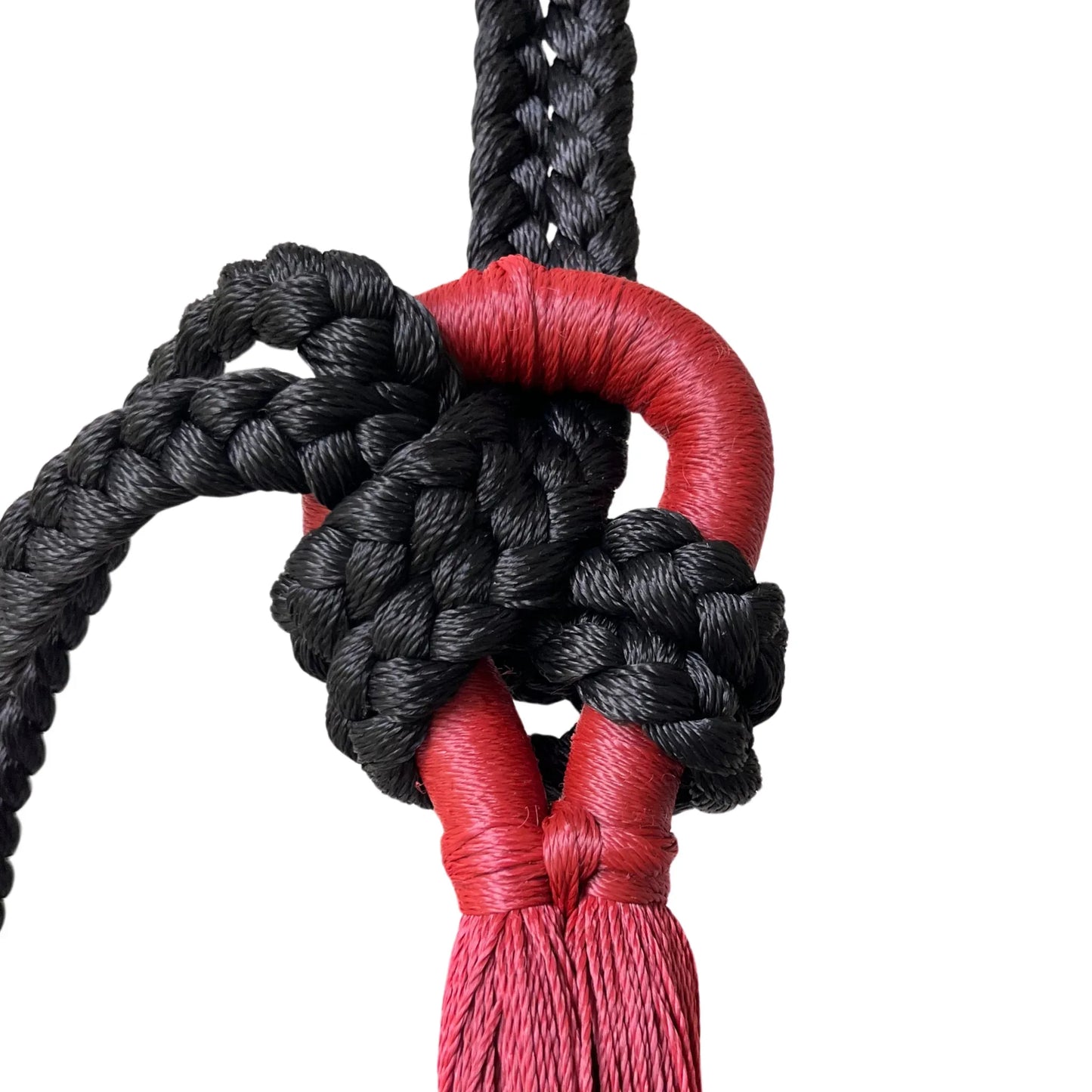 Nudo de cuerda de nylon negra artesanal unido al brazo de una hamaca