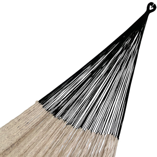 Detalle del brazo negro de una hamaca yucateca artesanal de algodón beige y negro con flecos decorativos