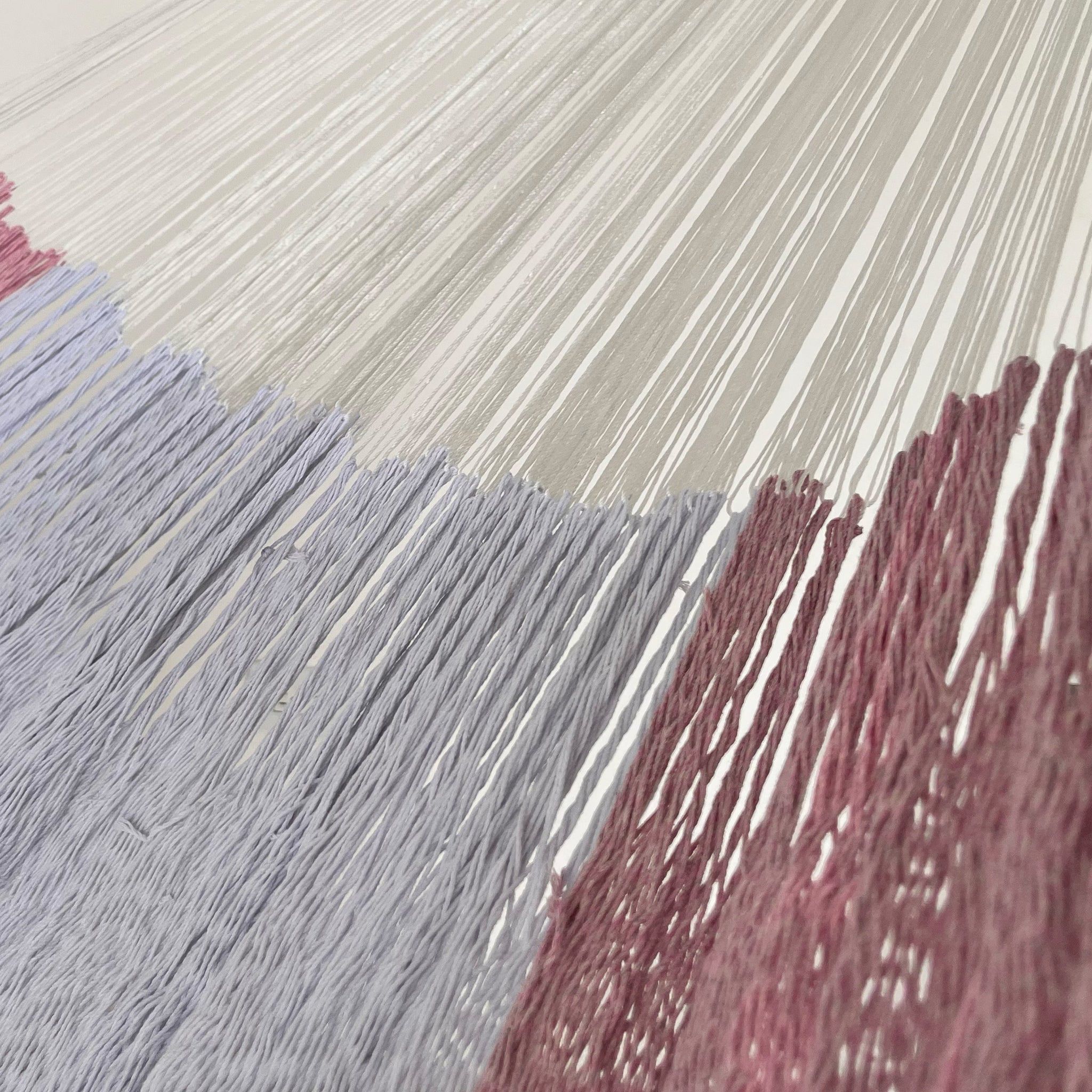 Unión entre cuerpo y brazo de hamaca Yucateca artesanal de algodón suave color rosa claro y blanco