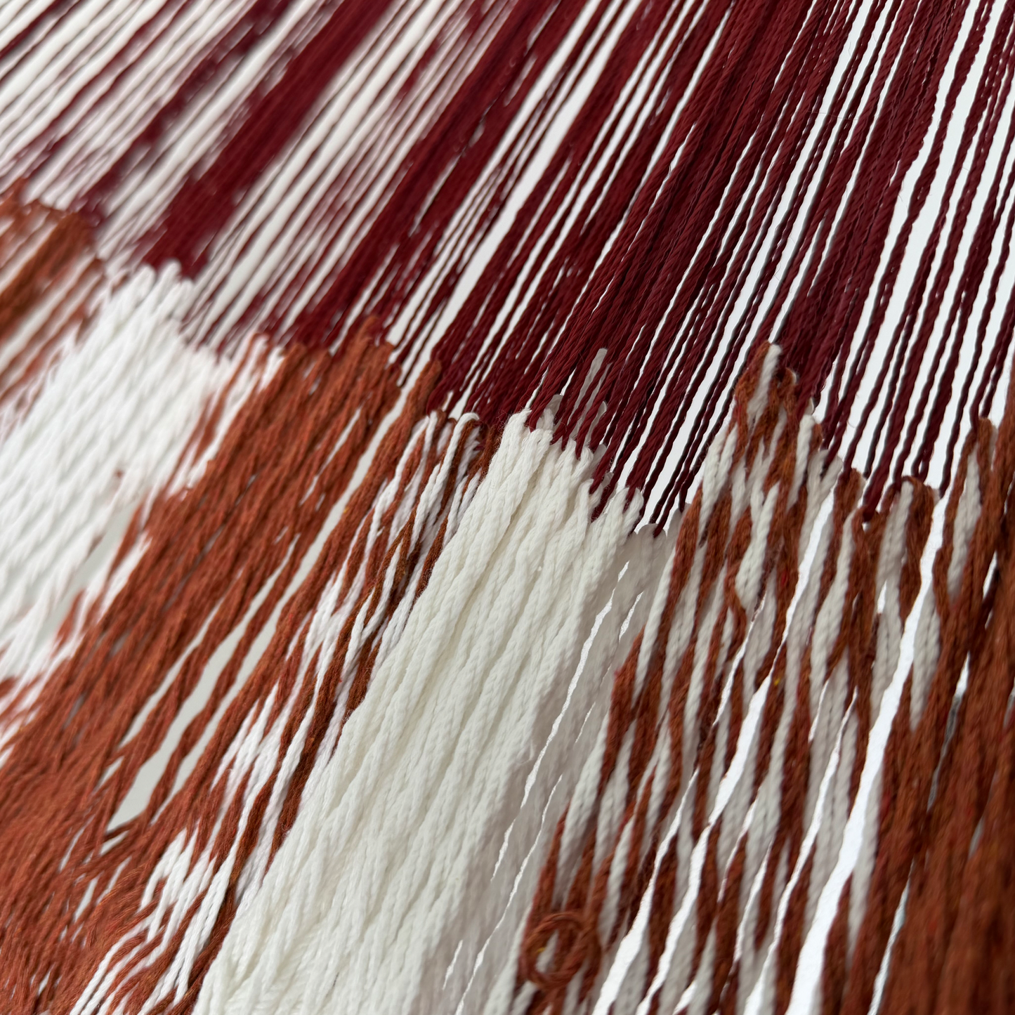 Unión entre el cuerpo y el brazo de hamaca Yucateca artesanal de algodón suave terracota y blanco