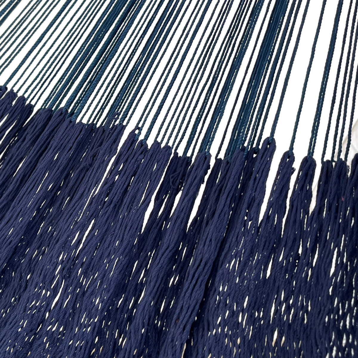 Detalle de la unión entre el cuerpo y el brazo de una hamaca yucateca artesanal de algodón azul con macramé