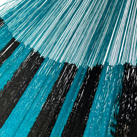 Detalle de la unión entre el cuerpo y el brazo de una hamaca yucateca artesanal de nylon suave azul y negro