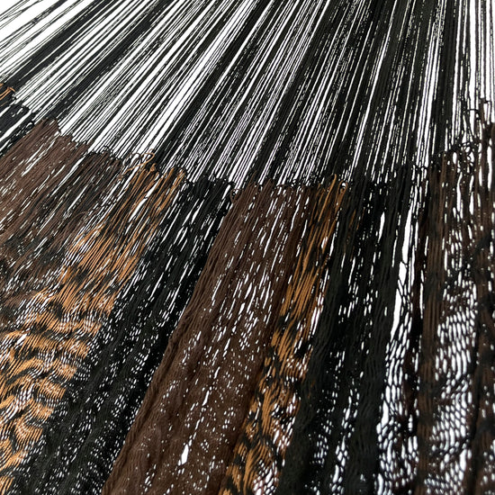 Detalle de la unión entre el cuerpo y el brazo de una hamaca yucateca artesanal de nylon suave café y negro