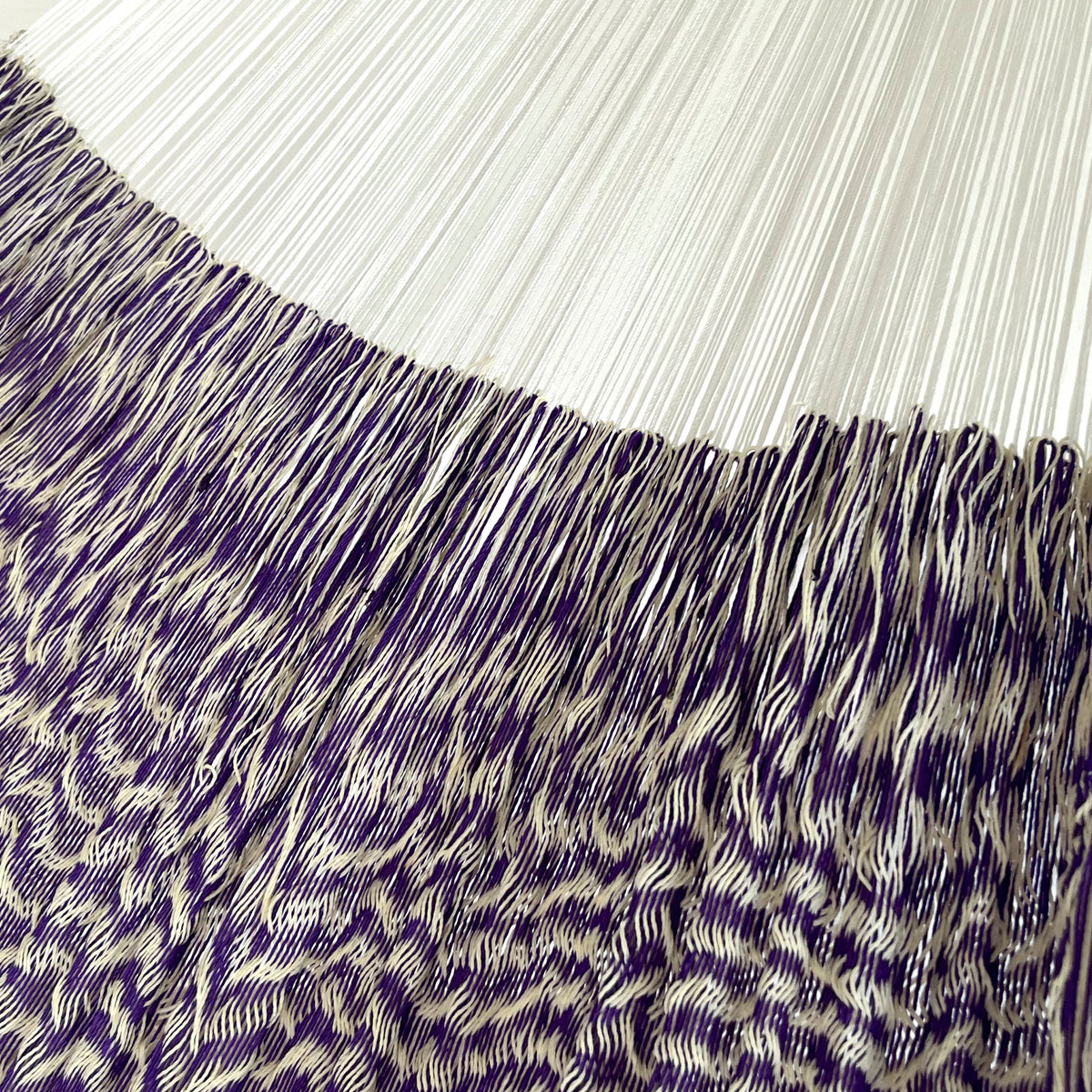 Detalle de la unión entre el cuerpo y el brazo de una hamaca yucateca artesanal de nylon suave morado y beige