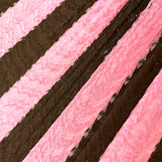 Primer plano del tejido de nylon suave de una hamaca yucateca artesanal color rosa y café