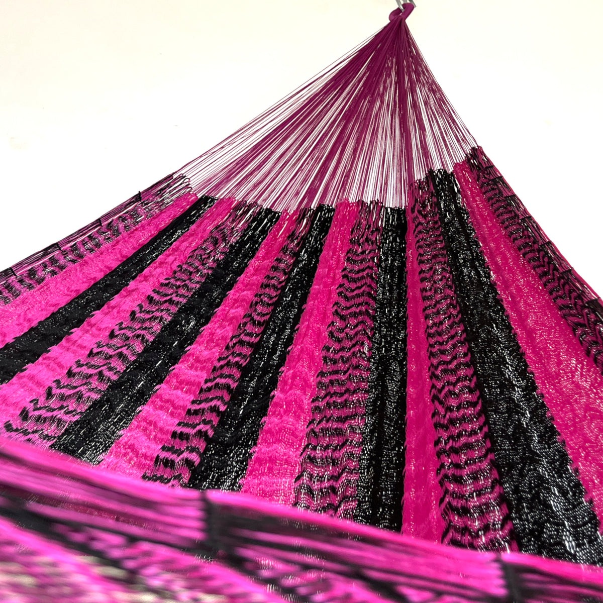 Interior de hamaca yucateca artesanal de nylon suave rosa y negro mostrando el tejido y el brazo
