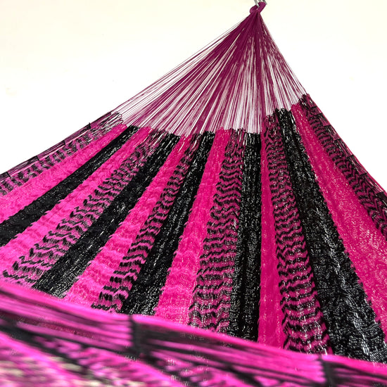 Interior de hamaca yucateca artesanal de nylon suave rosa y negro mostrando el tejido y el brazo
