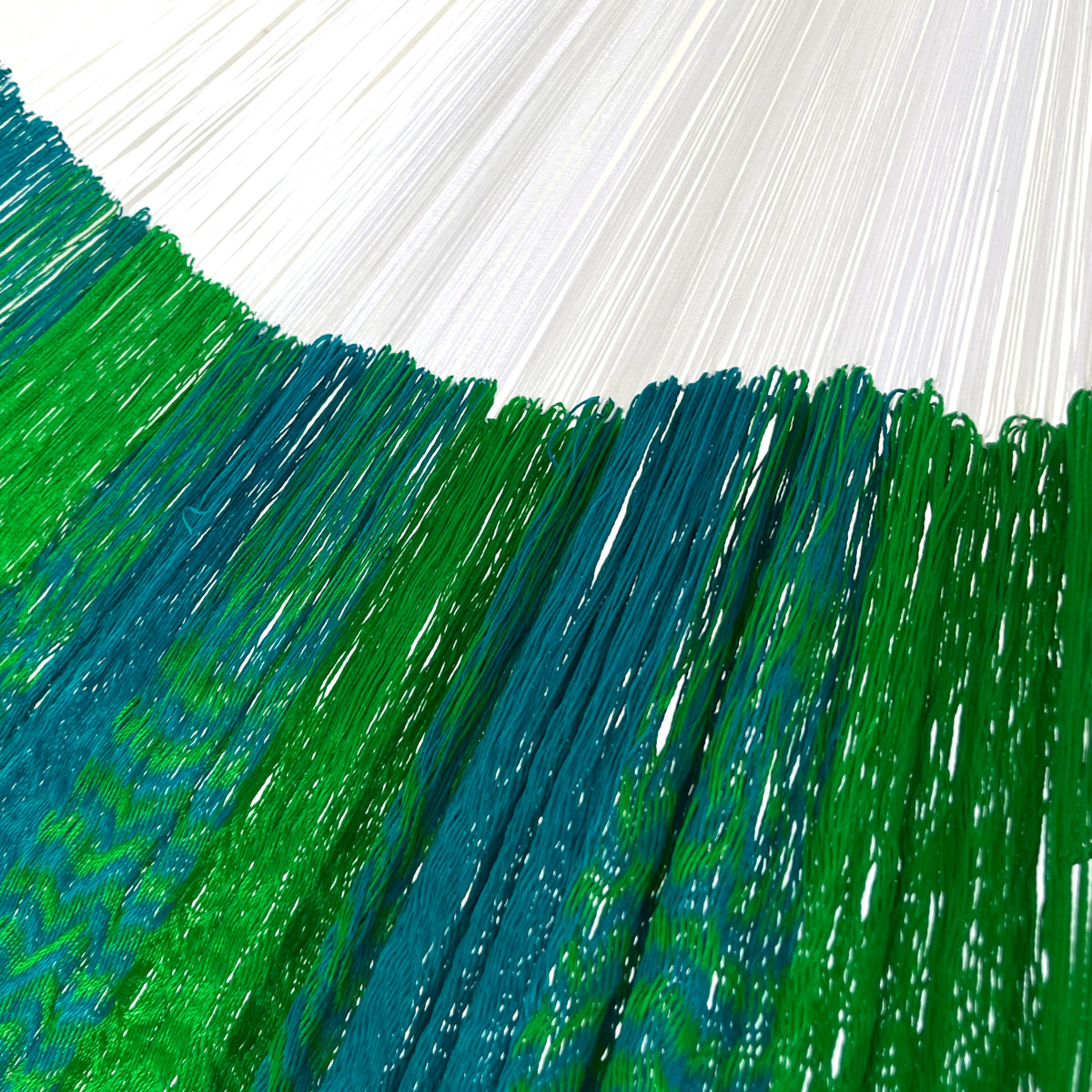 Detalle de la unión entre el cuerpo y el brazo de una hamaca yucateca artesanal de nylon suave verde y azul