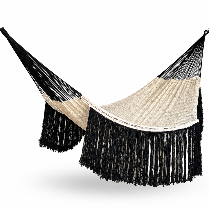 Hamaca yucateca artesanal de algodón beige y negro colgada y abierta con flecos largos decorativos sobre fondo blanco
