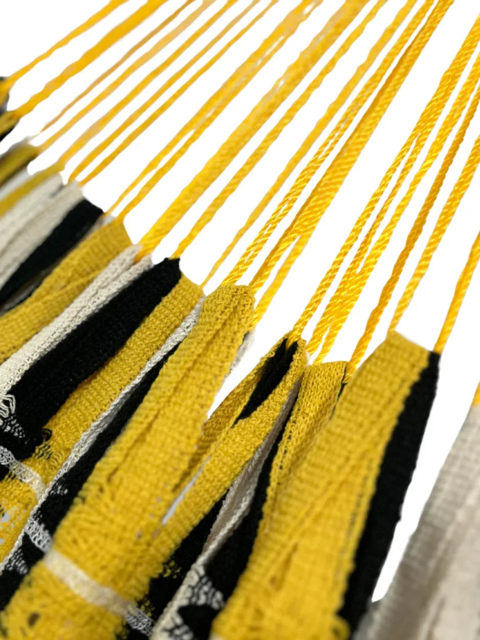 Detalle de la unión entre el brazo y el cuerpo de hamaca amarilla con beige y negro grande de algodón