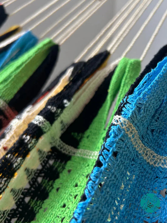 Detalle de la unión entre el brazo y el cuerpo de hamaca multicolor de algodón