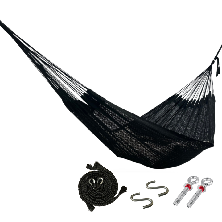 Hamaca negra de algodón colgada y abierta, junto a kit de instalación con sogas negras, ganchos en S y armellas sobre fondo blanco