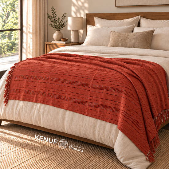 Manta mexicana de algodón color terracota sobre cama en recámara