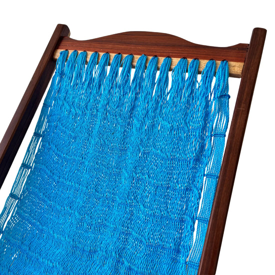 Detalle superior de silla mecedora artesanal plegable de Yucatán azul claro mostrando tejido y estructura de madera