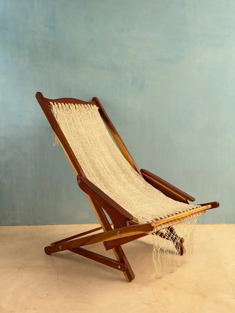 Silla mecedora artesanal plegable de Yucatán color beige abierta, colocada en exterior con vista lateral
