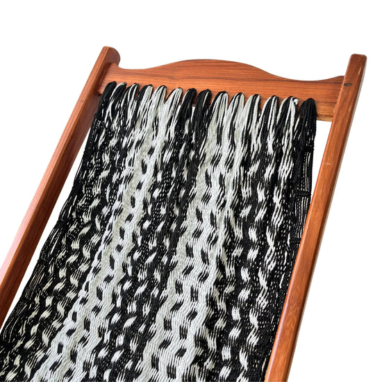 Detalle superior de silla mecedora artesanal plegable de Yucatán negra y gris mostrando tejido y estructura de madera