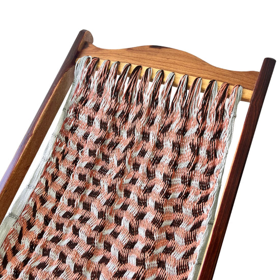 Detalle superior de silla mecedora artesanal plegable de Yucatán tricolor gris, rosa y café mostrando tejido y estructura de madera