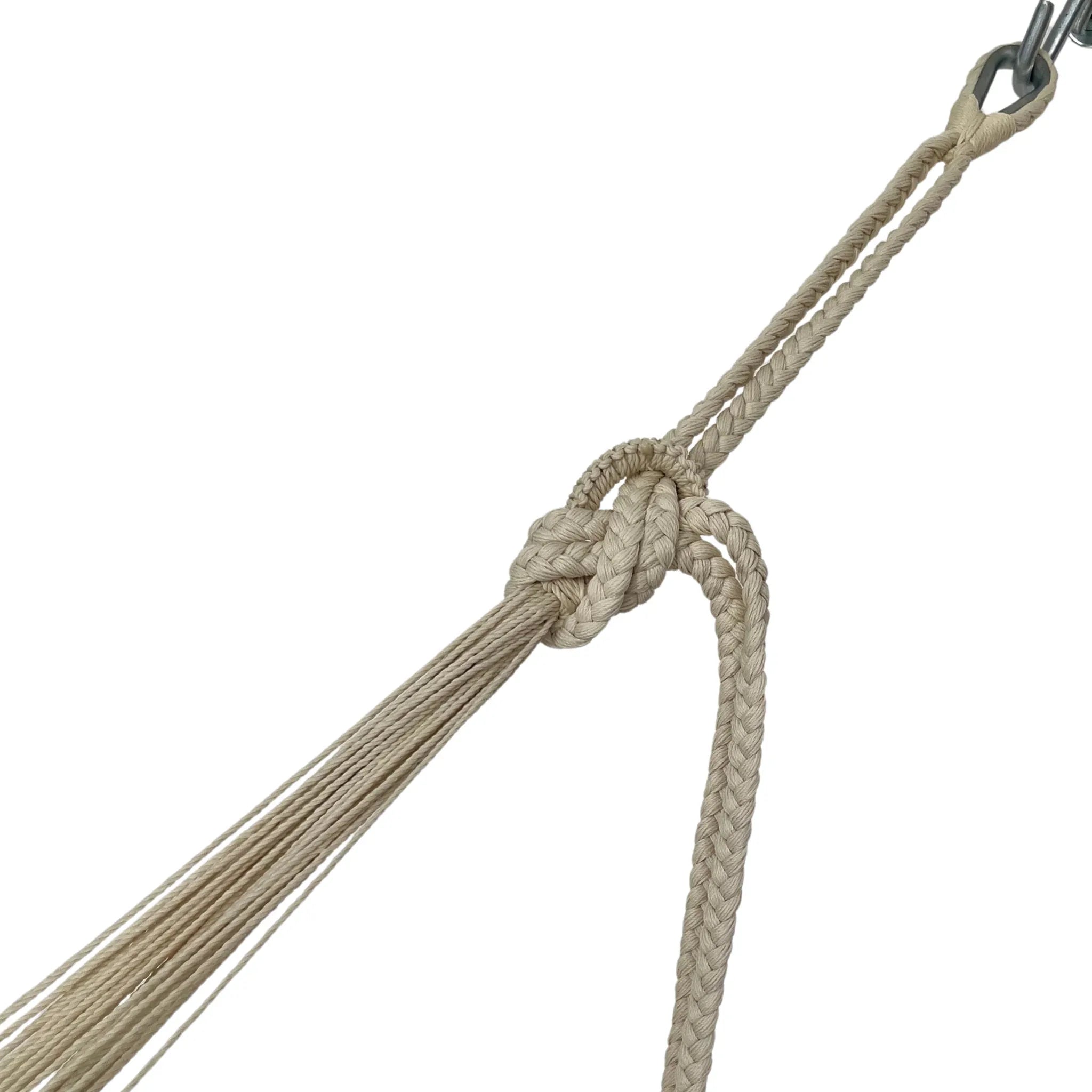 Cuerda de nylon beige artesanal con nudo unida al brazo de una hamaca mostrando más tramo de la cuerda